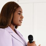Professional businesswoman delivering a speech while holding a microphone.