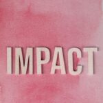 White text spelling 'IMPACT' on a pink watercolor wash evoking creativity and change.